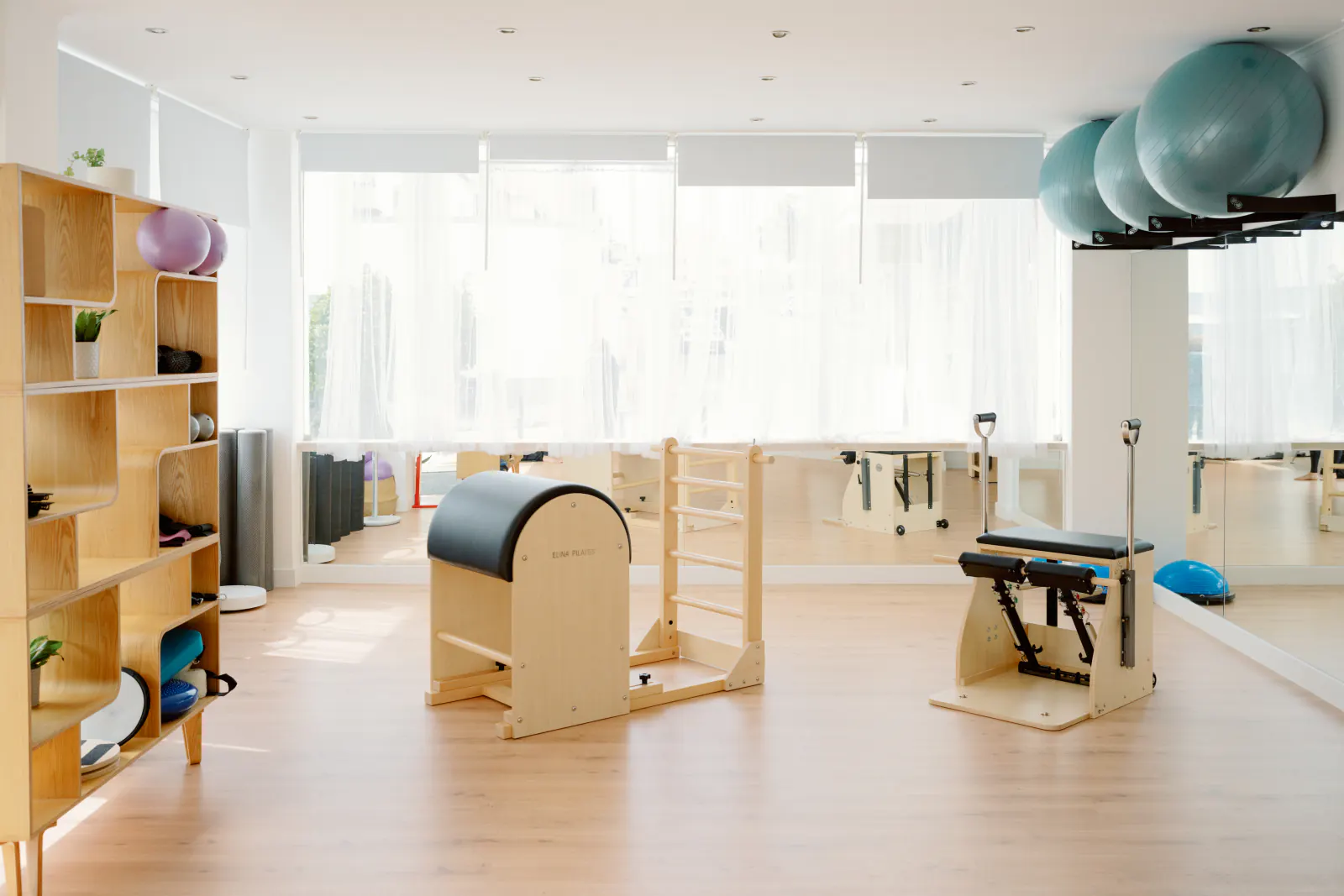 Sala de aparelhos com barril e escada de Pilates junto à janela